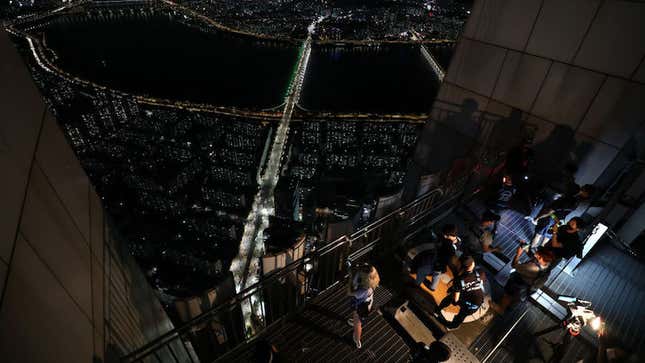 People take pictures and videos as they stay overnight on the rooftop of the Lotte World Tower as a way to safely social distance while camping in an urban setting on August 07, 2020 in Seoul, South Korea.