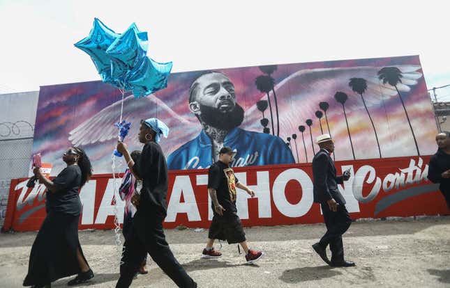 Fans walk as they wait outside The Marathon Clothing store for the funeral procession for slain rapper Nipsey Hussle on April 11, 2019 in Los Angeles, California. 