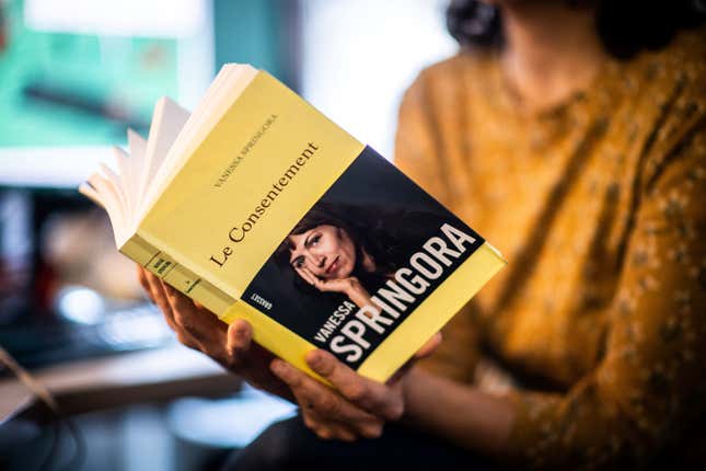 A woman holding the book “Le Consentement” (“The Consent”) by Vanessa Springora.