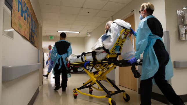 EMTs transferring a patient out of the acute care covid-19 unit at the Harborview Medical Center in Seattle, Washington on May 7, 2020