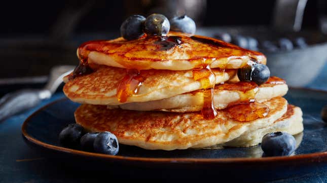 A stack of blueberry pancakes drenched in syrup... or are they???