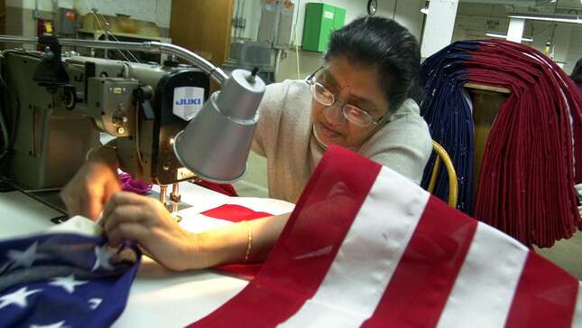 Sadgunaben Patel adjusts her sewing machine as she sews an American Flag at Annin Flags, April 7, 2003, in Oaks, Pennsylvania