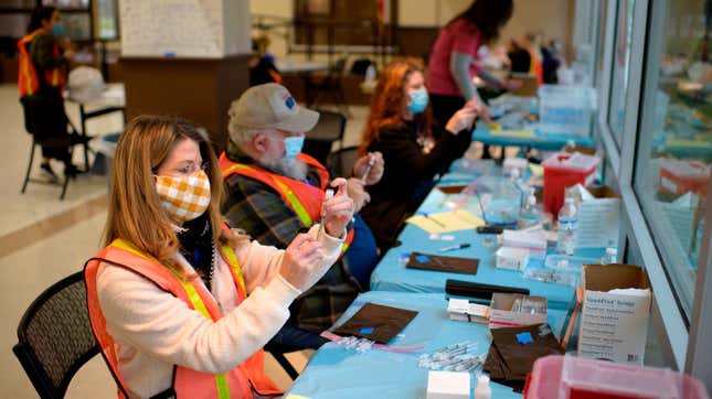 Volunteers and healthcare workers prepare covid-19 vaccine doses at a vaccination hub location in League City, Texas, on February 5, 2021.
