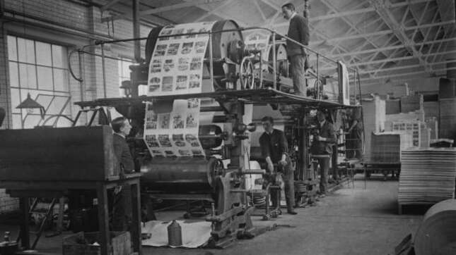circa 1930: A group of men operating a printing press.