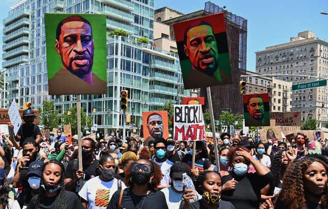 Protestors hold pictures of George Floyd as they march during a Juneteenth rally at Grand Army Plaza on June 19, 2020 in the Brooklyn Borough of New York City. - The US marks the end of slavery by celebrating Juneteenth, with the annual unofficial holiday taking on renewed significance as millions of Americans confront the nation’s living legacy of racial injustice. 