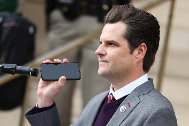 Rep. Matt Gaetz (R-Fla.) holds a phone to the microphone as Donald Trump Jr. speaks remotely to a crowd during a rally against Rep. Liz Cheney (R-WY) on January 28, 2021 in Cheyenne, Wyoming. Gaetz and Trump Jr. added their voices to a growing effort to vote Cheney out of office after she voted in favor of impeaching Donald Trump.