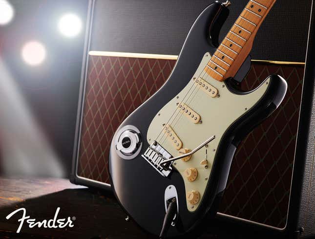 A Fender guitar sits next to an amp.