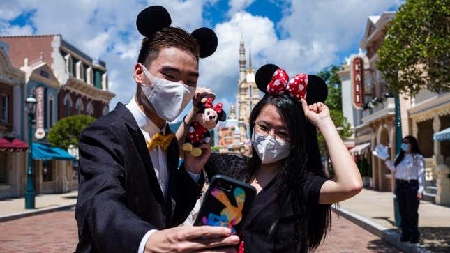 Visitors take a selfie at Hong Kong Disneyland on June 18, 2020.