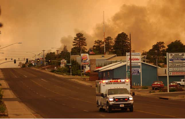 An ambulance from the towns of Heber and Overgaard on June 24, 2002 in Show Low, Arizona as smoke envelops the evacuated town during a wildfire.