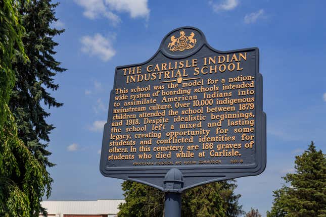 The historic marker at the gravesite of Native Americans that attended the Carlisle Indian Industrial School in Pennsylvania, where many Native American children were placed after being removed from their families and communities often as a result of discriminatory policies.