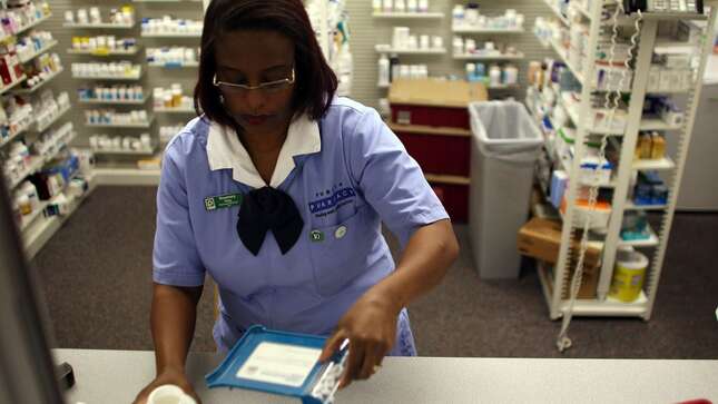 Rosemary Petty, a Publix Supermarket pharmacy technician, counts out a prescription of antibiotic pills August 7, 2007 in Miami, Florida.