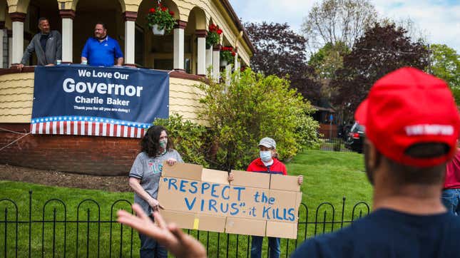 A bystander argues with protestors outside the home of Massachusetts Governor Charlie Baker