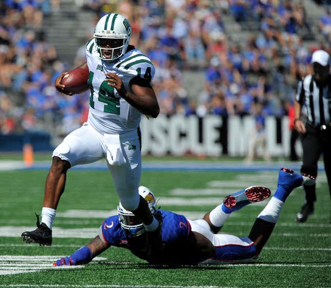 Quarterback Greg Windham #14 of the Ohio Bobcats slips past Dorance Armstrong Jr. #2 of the Kansas Jayhawks as he runs for a touchdown.