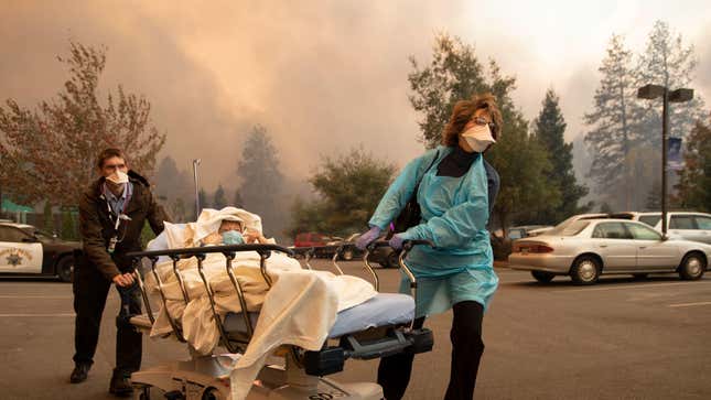 Patients are quickly evacuated from the Feather River Hospital as it burns down during the Camp fire in Paradise, California on Nov. 8, 2018.