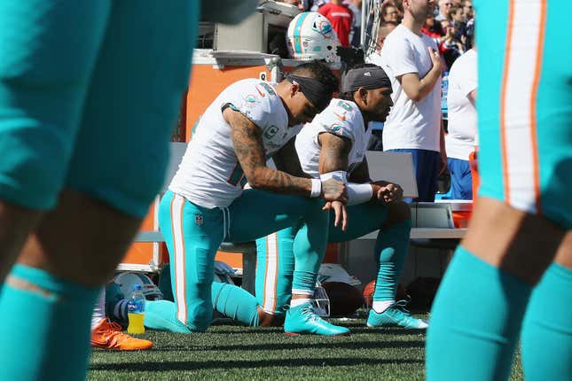 Kenny Stills #10 and Albert Wilson #15 of the Miami Dolphins kneel during the national anthem prior to their game against the New England Patriots at Gillette Stadium on September 30, 2018 in Foxborough, Massachusetts. 