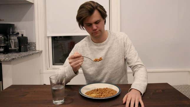 Noah Willson eats a bowl of beans in his kitchen.