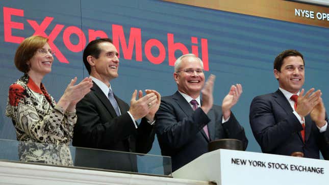 Exxon Mobil CEO Darren Woods claps at the New York Stock Exchange in 2017. It’s unclear when he’ll be invited back.