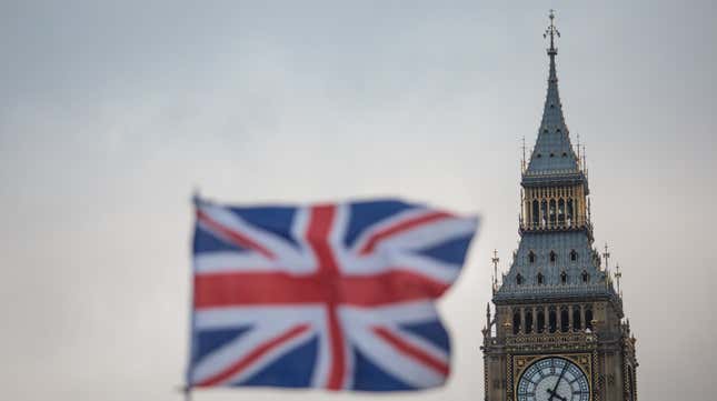 A Union Jack flag flutters in front of Big Ben in London, England. 