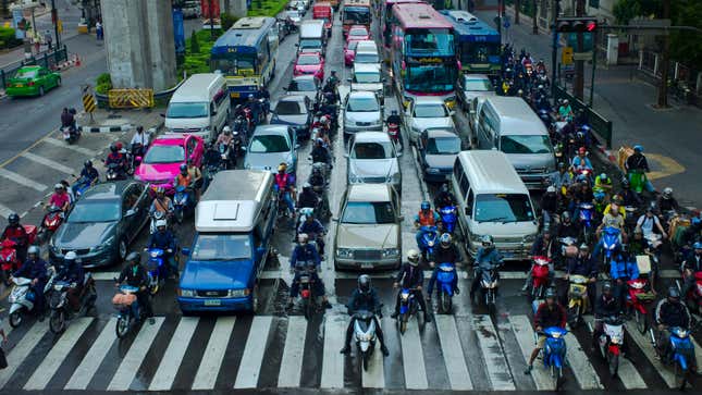 Scooters and motorcycles filtering lanes in Bangkok traffic