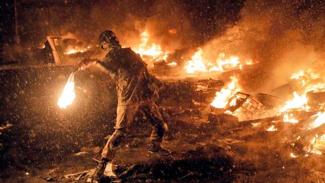 In this Wednesday, Jan. 22, 2014 file photo a protester throws a Molotov cocktail during clashes with police in central Kiev, Ukraine.