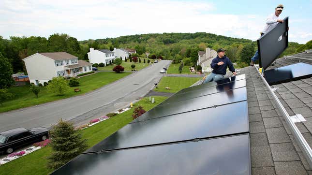 Workers install panels on the roof of a home in Newburgh, New York. 