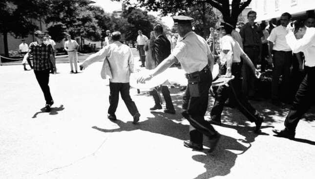 One of the gunman’s victims is carried across the campus to a waiting ambulance in Austin on August 1, 1966. Photo via AP.