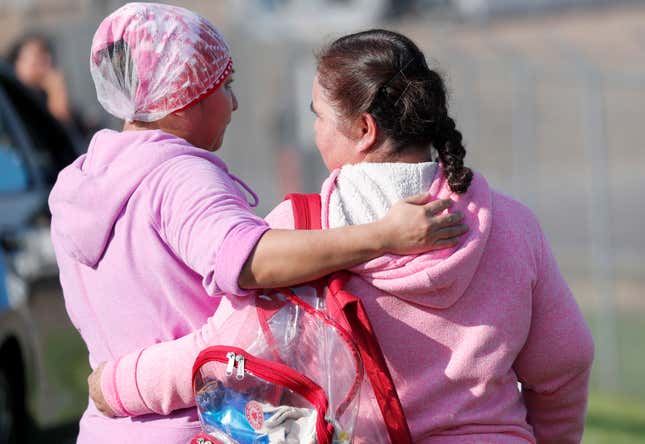 Friends and family console each other while U.S. immigration officials raided Koch Foods Inc., plant in Morton, Miss.,  Aug. 7, 2019. 