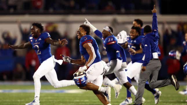 Members of the Kansas Jayhawks storm the field and celebrate as they defeat the Texas Tech Red Raiders during an Oct. 26, 2019, game. The NCAA is looking to change its rules to allow players like these to profit off their own names and images. 