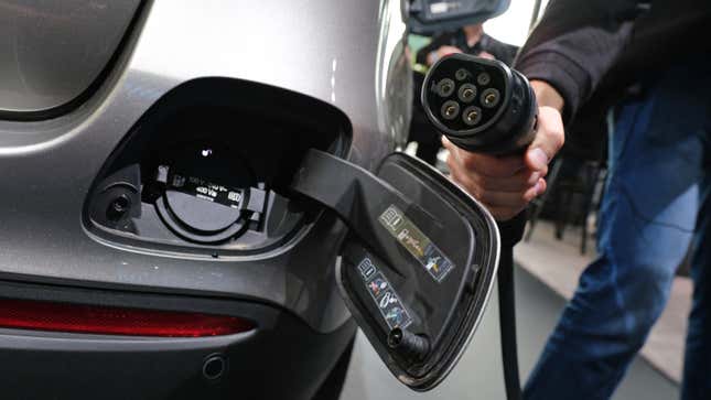 FRANKFURT AM MAIN, GERMANY - SEPTEMBER 09: A journalist holds a charging cable next to the electric charging port as the fuel cap is open behind on a Mercedes-Benz GLC 300e plug-in hybrid at the Mercedes-Benz media preview at the 2019 IAA Frankfurt Auto Show on September 09, 2019 in Frankfurt am Main, Germany. The IAA will be open to the public from September 12 through 22. (Photo by Sean Gallup/Getty Images)