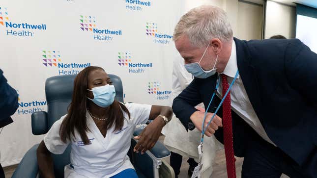Nurse Sandra Lindsay bumps elbows with hospital publicist Joseph Kemp after she is inoculated with the covid-19 vaccine, December 14, 2020 at the Long Island Jewish Medical Center, in the Queens borough of New York City.