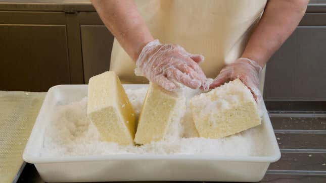 Person handling cheese with gloves on