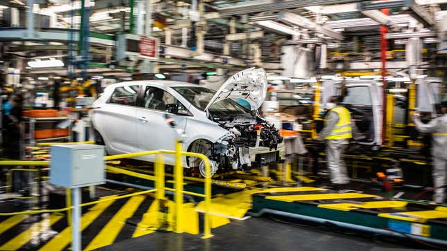 Employees wearing protective masks against the spread of the novel coronavirus, COVID-19, work along the assembly line that produces both the electric vehicle Renault Zoe and the hybrid vehicle Nissan Micra, at Flins-sur-Seine, the largest Renault production site in France on May 6, 2020