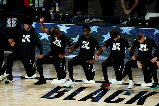 Lance Thomas of the Brooklyn Nets gestures as he and teammates kneel in honor of the Black Lives Matter movement prior to an NBA basketball game against the Portland Trail Blazers at AdventHealth Arena at ESPN Wide World Of Sports Complex on August 13, 2020 in Lake Buena Vista, Florida. 