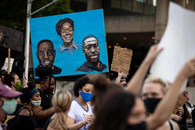 Protesters carry a painting of Ahmaud Arbery, left, Breonna Taylor and George Floyd while marching on June 5, 2020 in Louisville, Ky. 