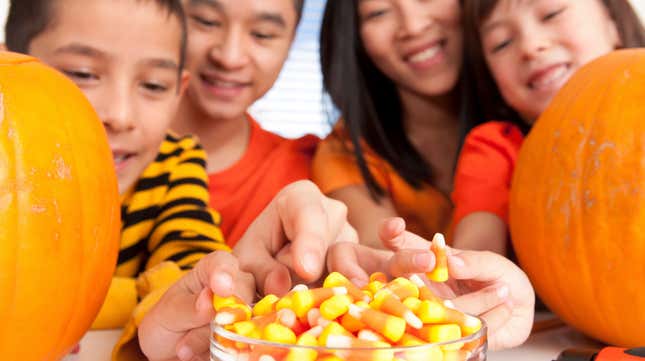 Family all reaching for candy corn from the same bowl