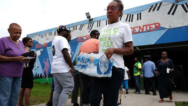  A woman leaves a recreation center after receiving free bottled water on Aug. 13, 2019, in Newark, N.J.