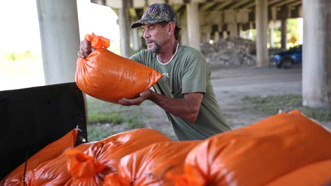 A man fills sandbags as he prepares for the arrival of Marco and Laura on August 24, 2020 in Morgan City , Louisiana. 
