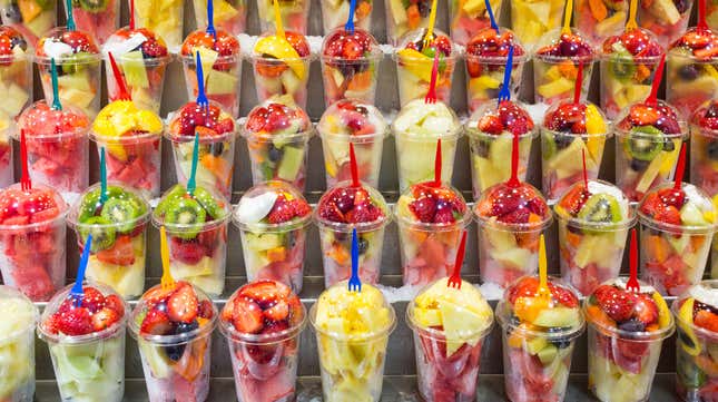 Shelves full of plastic containers of fruit salad for sale