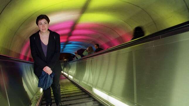 A Metro passenger stares at colored lights projected on the ceiling of the south entrance escalator tunnel of the Dupont Circle Metro station in Washington, D.C., March 16, 2000.