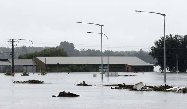 Debris floats past a partially submerged business flooded by water from the Hawkesbury River in Windsor, northwest of Sydney.