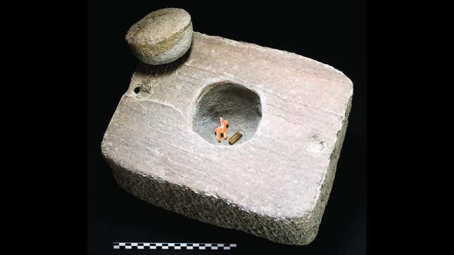 The stone container with llama figurine and gold bracelet inside. 