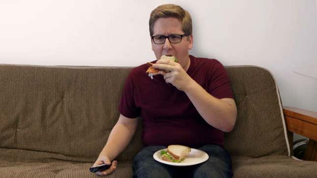 Image for article titled Man Concerned He Spread Himself Too Thin Between Eating Sandwich, Watching Television