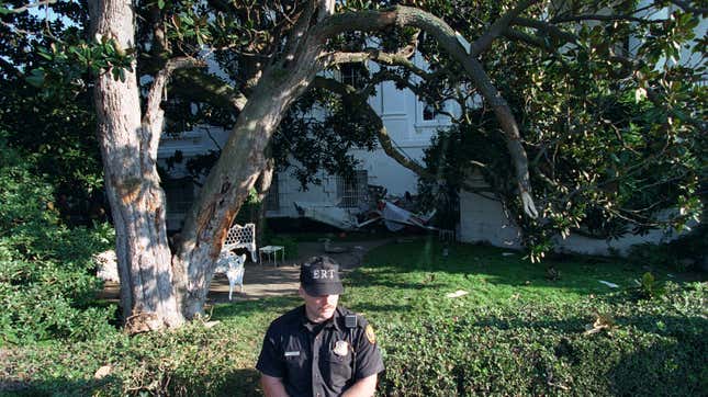 A uniformed Secret Service agent stands guard over the wreckage of a single-engine plane, which rests against the South Portico near the Rose Garden at the White House in Washington, D.C., Monday, Sept. 12, 1994.
