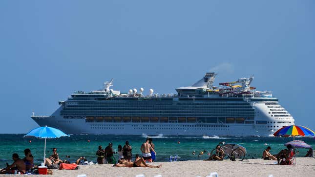 A cruise ship sails in the background as people relax in Miami Beach, Florida on July 2, 2020. 