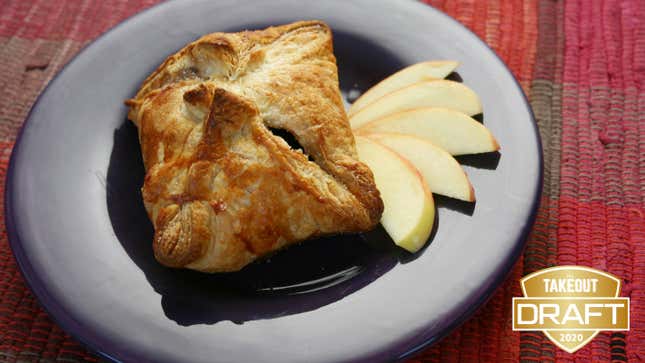 Apple dumpling on a plate beside sliced apples