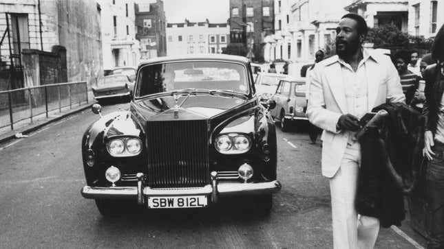 American soul singer Marvin Gaye (1939 - 1984) walking ahead of his Rolls Royce in Notting Hill, London.