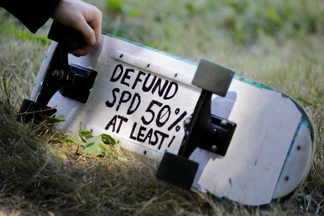 A defund Seattle Police Department (SPD) sign is pictured on a protester’s skateboard during a “Defund the Police” march from King County Youth Jail to City Hall in Seattle, Washington on August 5, 2020. 