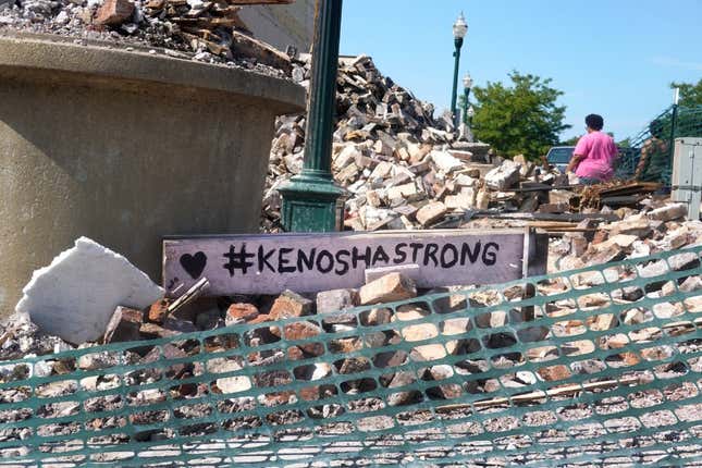 People walk past a building that was reduced to rubble after being burned during recent rioting following the shooting of Jacob Blake on August 28, 2020, in Kenosha, Wis. Blake remains in the hospital after being shot seven times in the back in front of his three children by a police officer. 