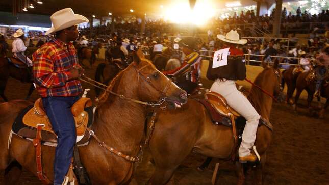 Participants of the 18th annual Bill Pickett Invitational Rodeo ride their horses at the start of the event July 21, 2001 in Los Angeles, CA.
