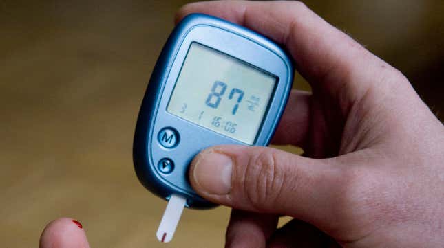 A person measuring their blood sugar level through a finger prick test. 